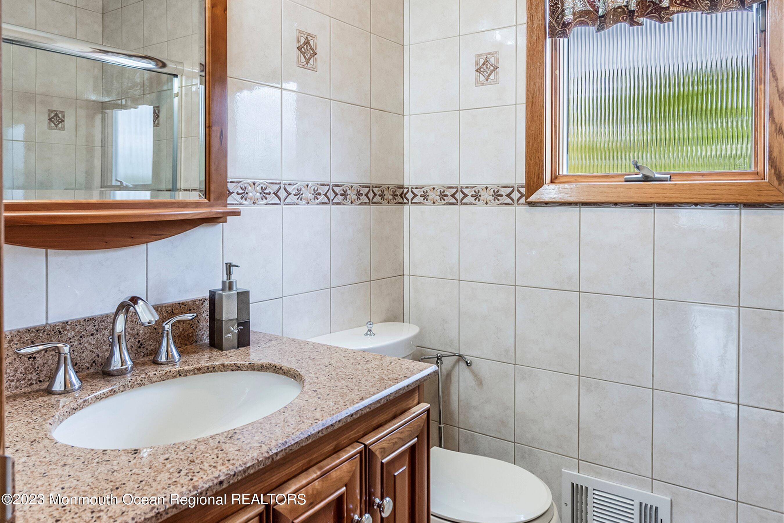 1 Hearth Court Howell, NJ 07731 - Photo 18 of 23 a bathroom with a granite countertop sink and a mirror