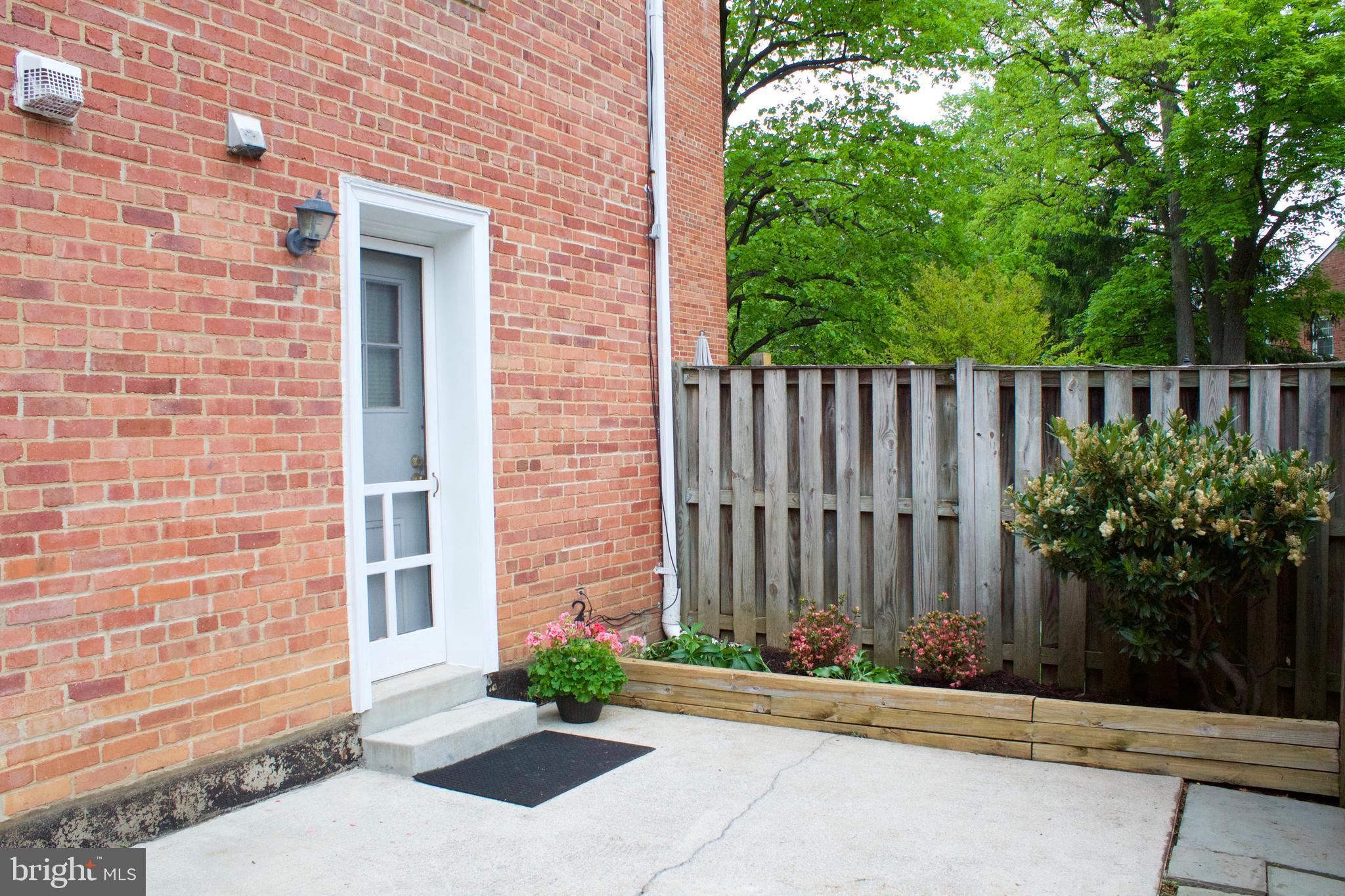 6709 Fairfax Road, Unit 72 Chevy Chase, MD 20815 - Photo 21 of 37 a view of a brick house with plants and wooden walls
