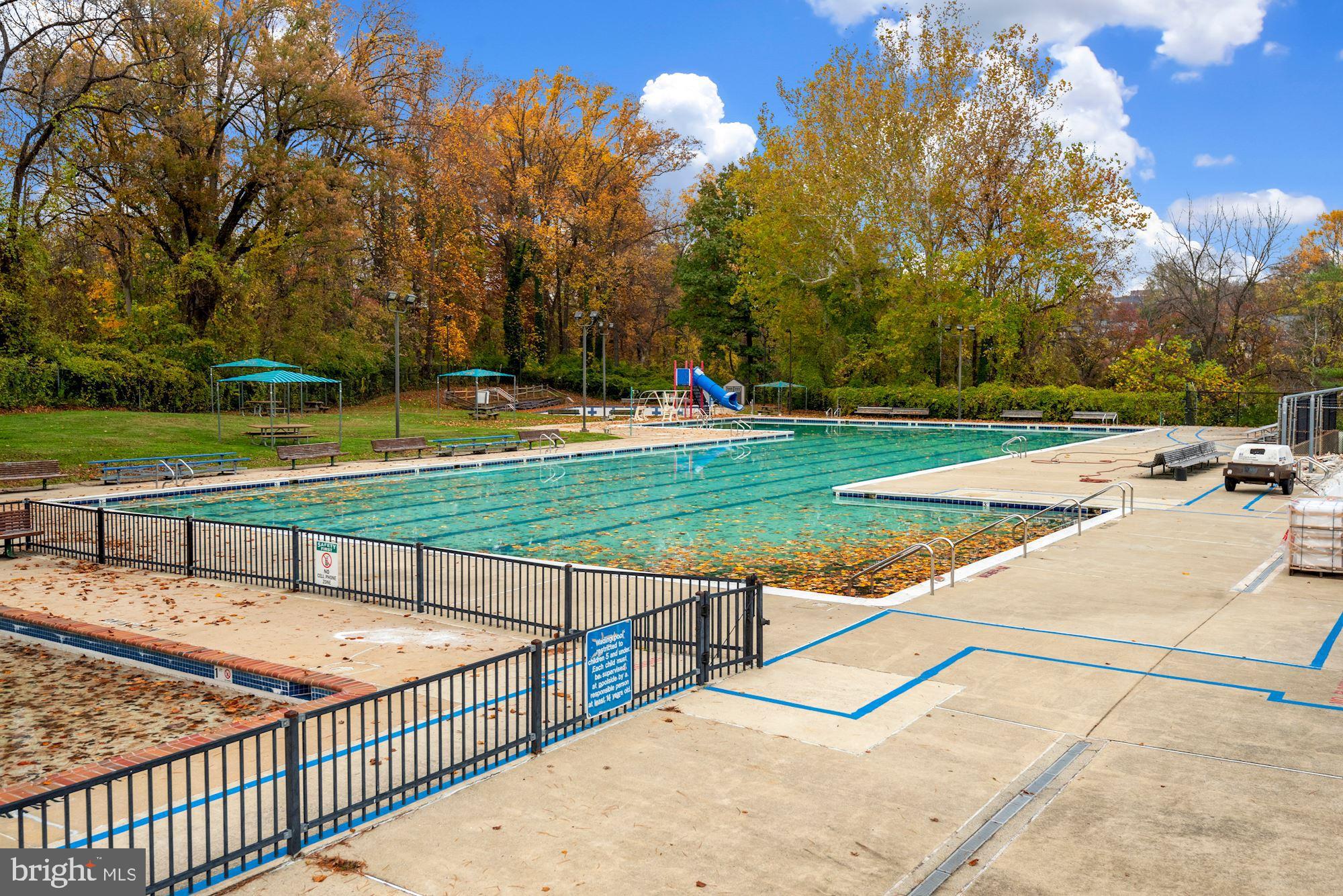 6709 Fairfax Road, Unit 72 Chevy Chase, MD 20815 - Photo 27 of 37 a view of a swimming pool with a bench and trees around