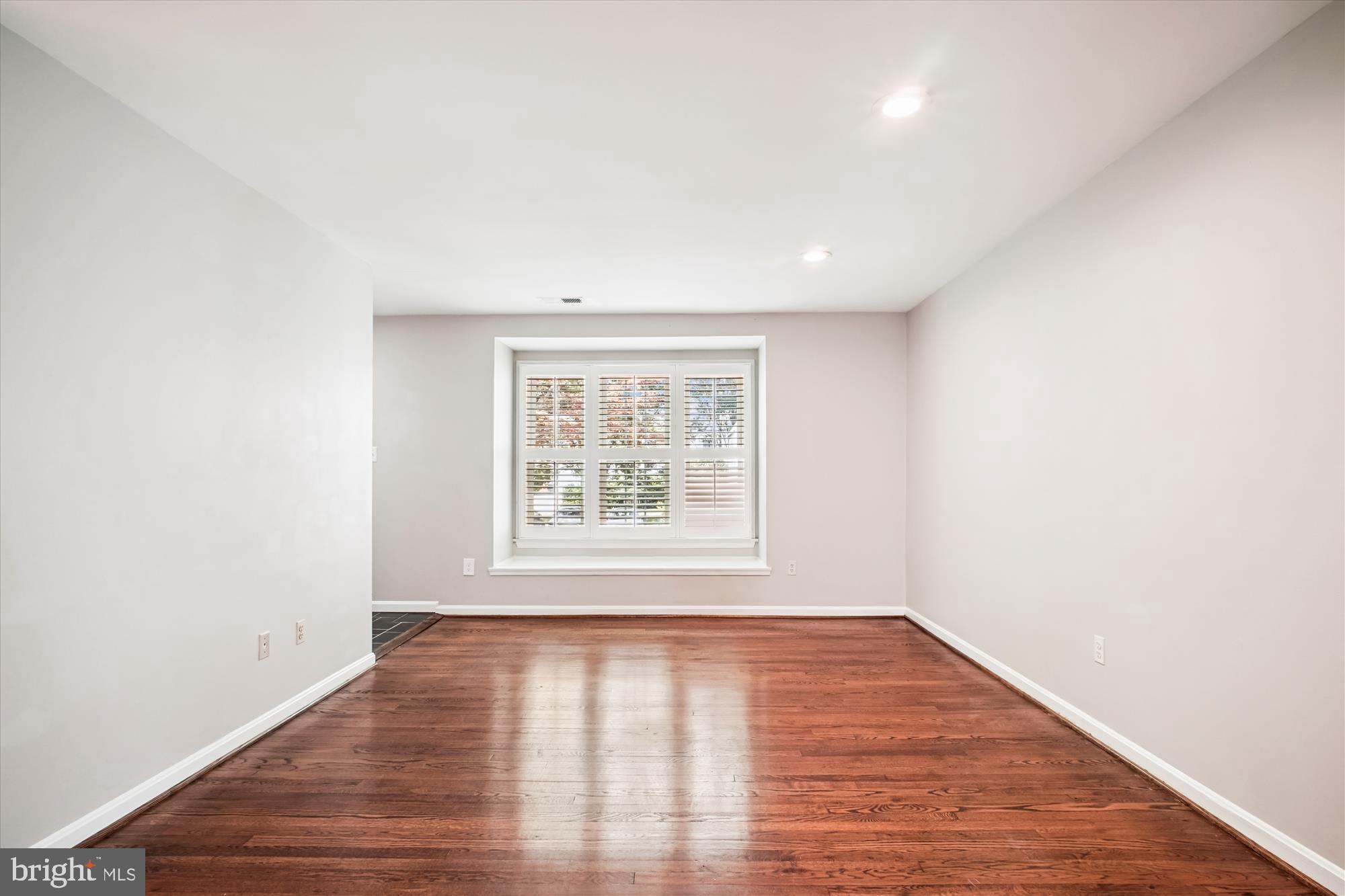 6709 Fairfax Road, Unit 72 Chevy Chase, MD 20815 - Photo 3 of 37 an empty room with wooden floor and windows