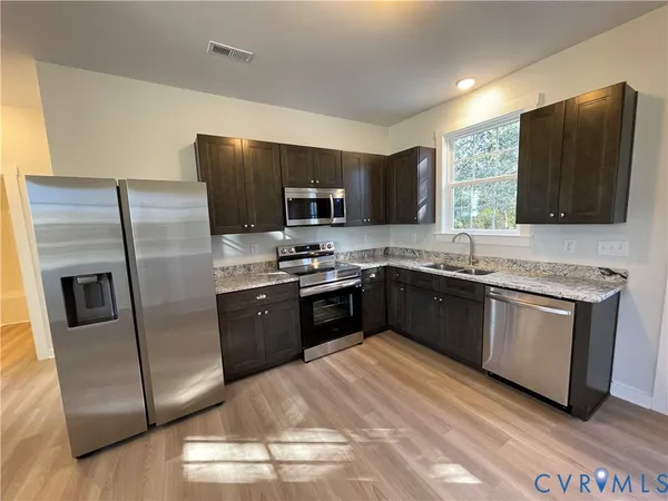 a kitchen with stainless steel appliances granite countertop a refrigerator stove a sink and dishwasher
