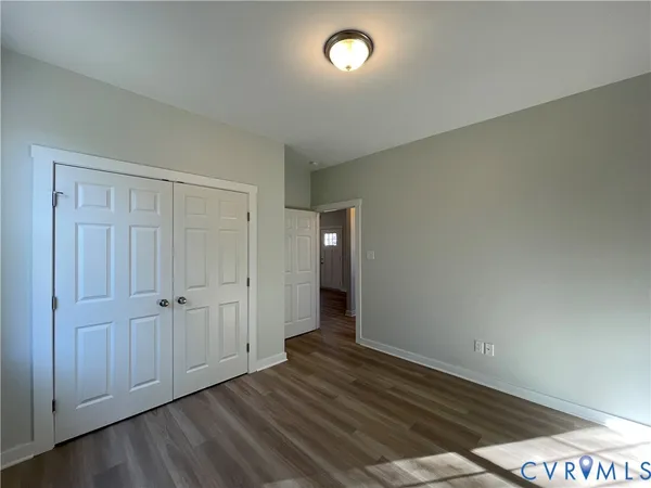 an empty room with wooden floor and closet area