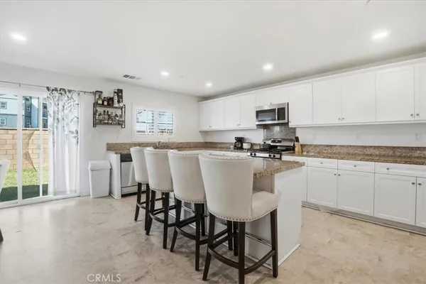 a large kitchen with stainless steel appliances granite countertop a lot of counter space and a sink