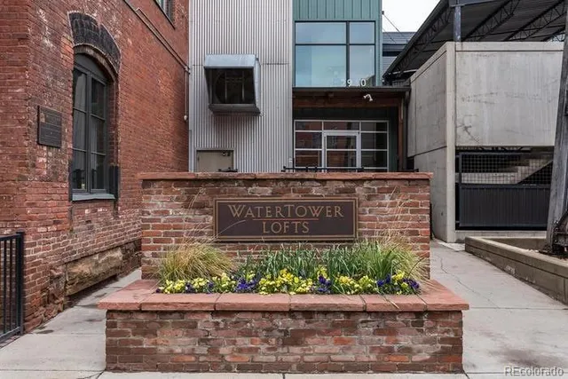 a front view of a building with a garden and plants