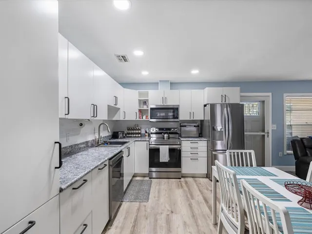 a kitchen with stainless steel appliances granite countertop a refrigerator stove and sink