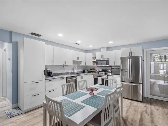 a bathroom with a granite countertop toilet a sink and mirror