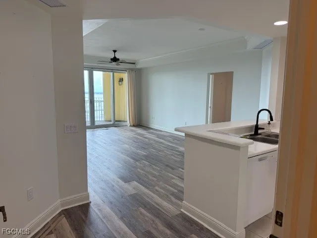 a view of an empty room with window and wooden floor