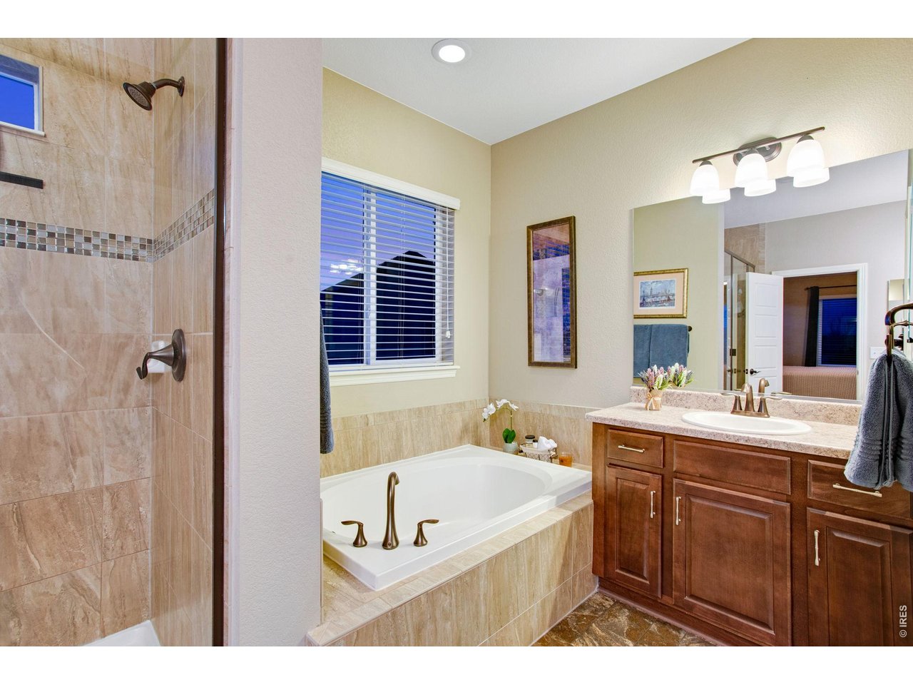 5728 Connor Street Timnath, CO 80547 - Photo 25 of 50 a bathroom with a tub a sink and mirror