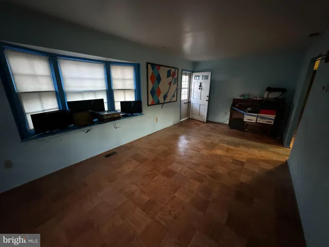 a view of an empty room with a window and fireplace