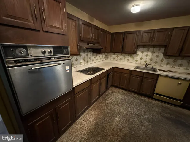 a kitchen with granite countertop wood cabinets and stainless steel appliances