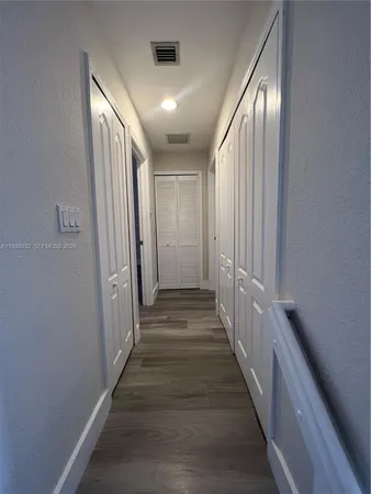 a view of a hallway with wooden floor and staircase