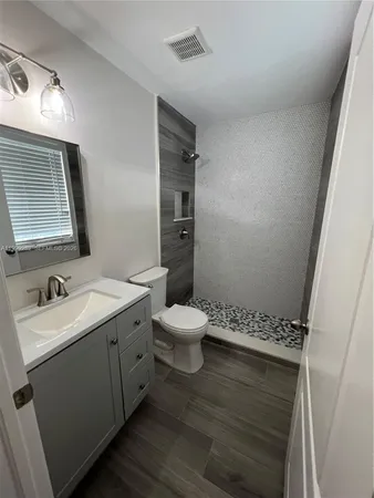 a bathroom with a toilet a sink and mirror