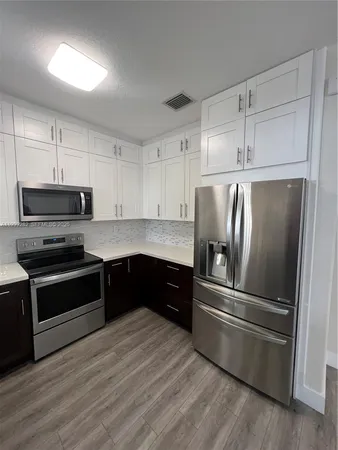 a kitchen with a refrigerator stainless steel appliances and cabinets