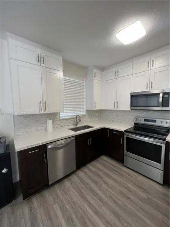 a large kitchen with stainless steel appliances granite countertop a stove and a sink