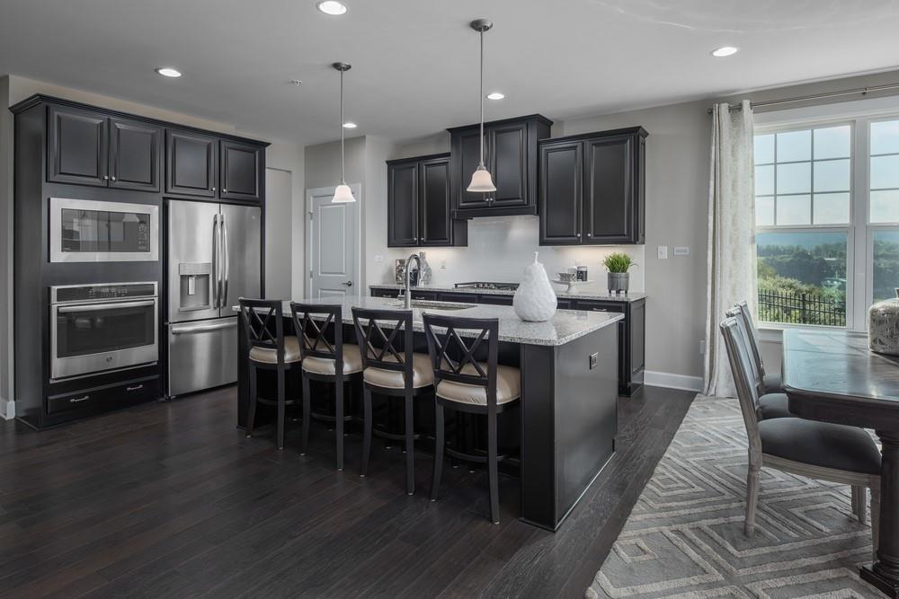 4701 Spruce Road Gibsonia, PA 15044 - Photo 6 of 9 a kitchen with stainless steel appliances kitchen island granite countertop a stove a refrigerator a sink a dining table and chairs with wooden floor