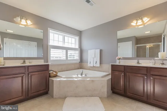 a spacious bathroom with a tub a sink and a window