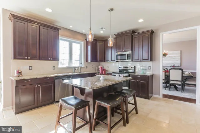 a kitchen with granite countertop wooden cabinets a stove a sink and a island