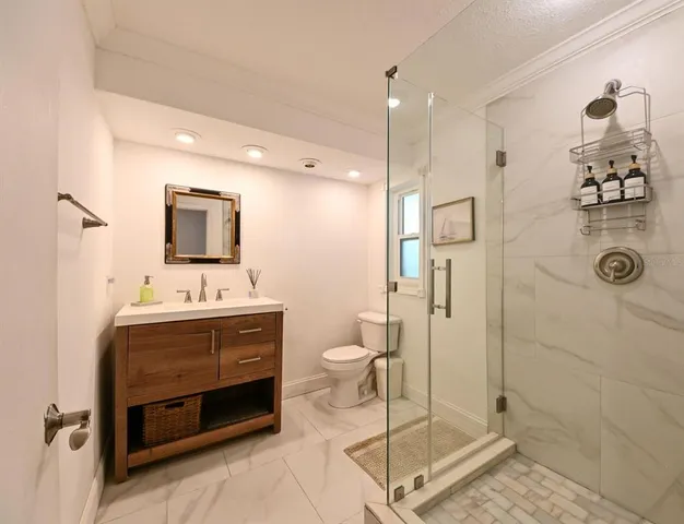 a bathroom with a sink a toilet and shower