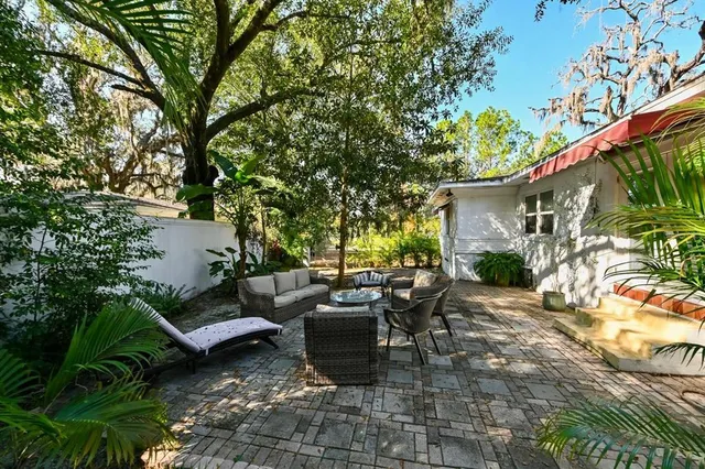 a view of a patio with couches table and chairs and potted plants