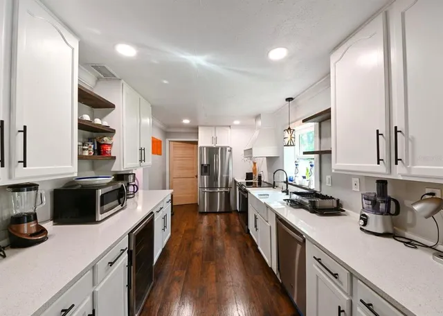 a kitchen with a sink stove top oven and refrigerator