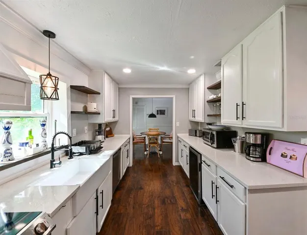 a kitchen with kitchen island granite countertop a sink a counter top space stainless steel appliances and cabinets