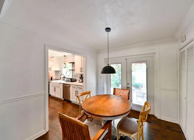 a dining room with furniture a chandelier and wooden floor