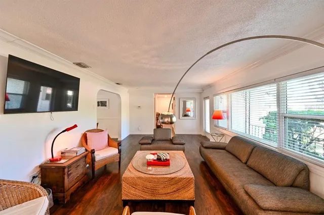 a living room with furniture a flat screen tv and a large window