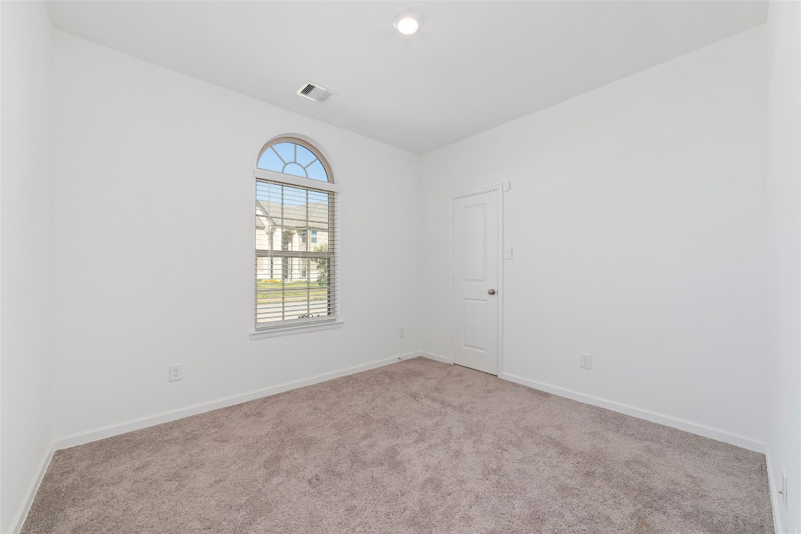 11023 Abendstern Road Tomball, TX 77375 - Photo 19 of 26 an empty room with windows and exposed radiator
