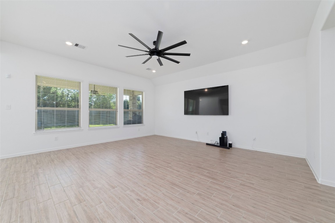11023 Abendstern Road Tomball, TX 77375 - Photo 7 of 26 a view of a livingroom with a flat screen tv ceiling fan and hardwood floor