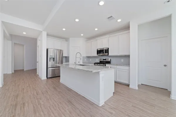 a kitchen with stainless steel appliances a refrigerator and a stove top oven