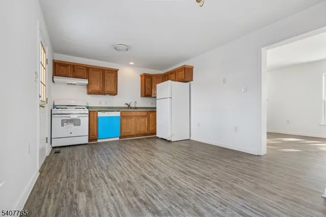a view of kitchen with stainless steel appliances granite countertop a stove and a refrigerator