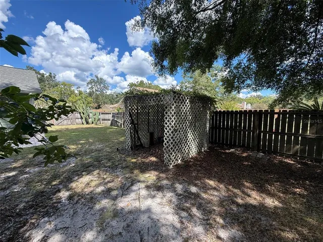 a view of a yard with wooden fence