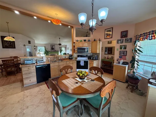 a open dining room with kitchen island furniture a chandelier a kitchen view and a counter top space