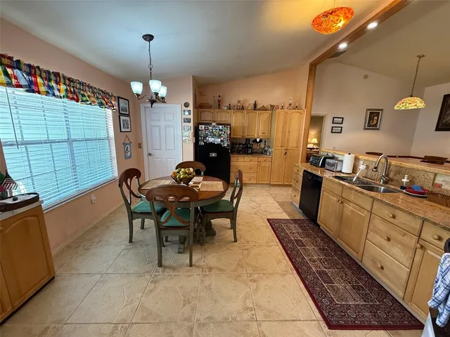 a kitchen with granite countertop a stove a sink a dining table and chairs with wooden floor