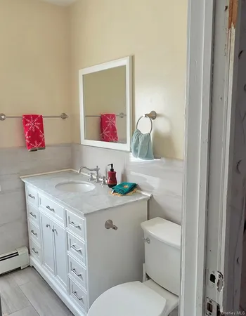 a bathroom with a granite countertop toilet sink and mirror
