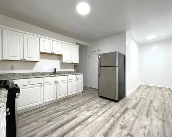 a kitchen with a refrigerator sink and cabinets