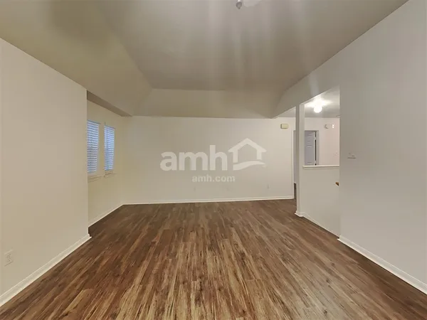 a view of wooden floor and a chandelier fan in a room
