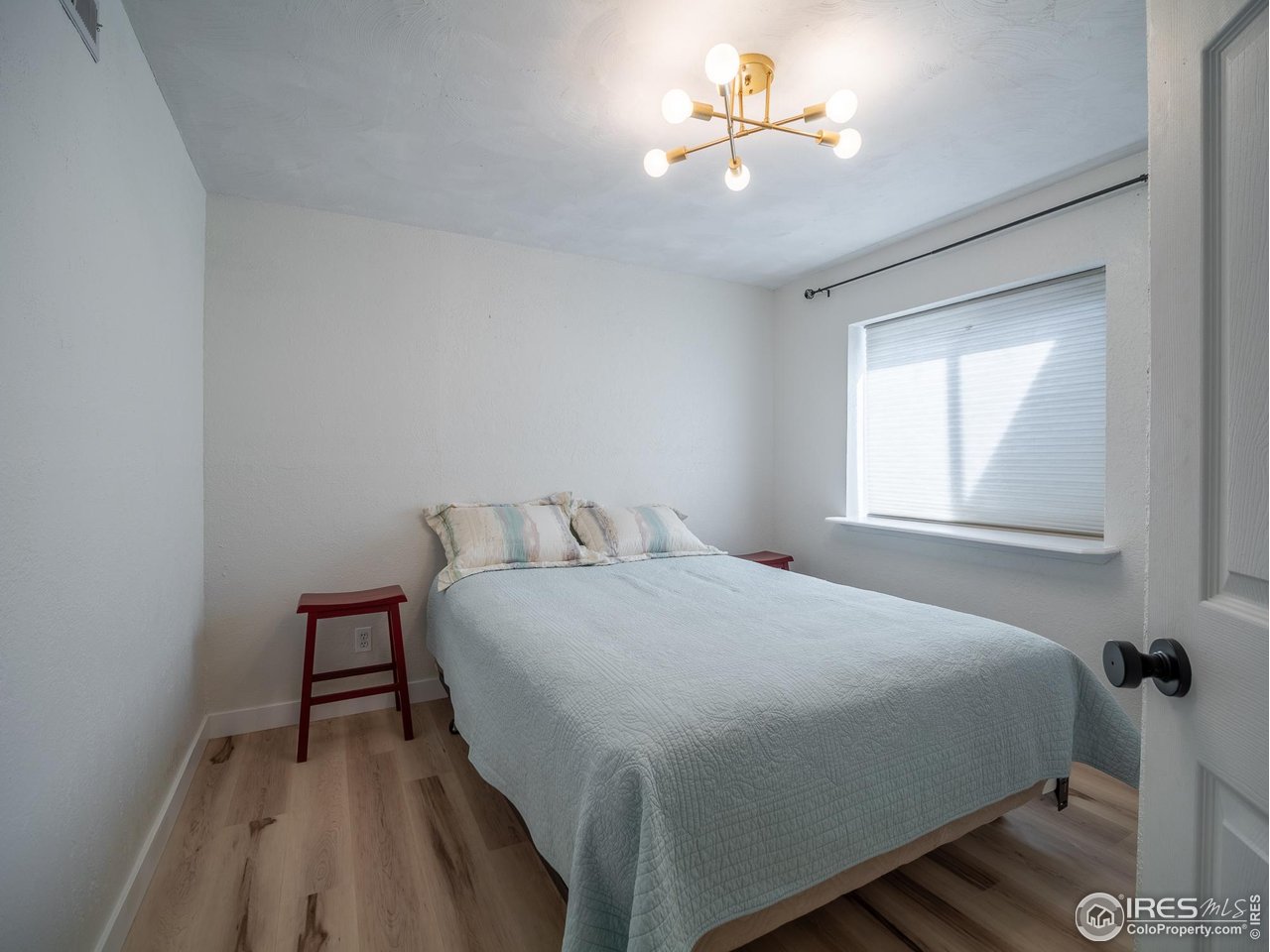 13146 Raritan Court Denver, CO 80234 - Photo 32 of 41 a bedroom with a bed and a chandelier