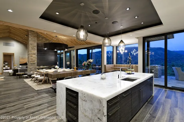 an open kitchen with a sink and white cabinets with wooden floor
