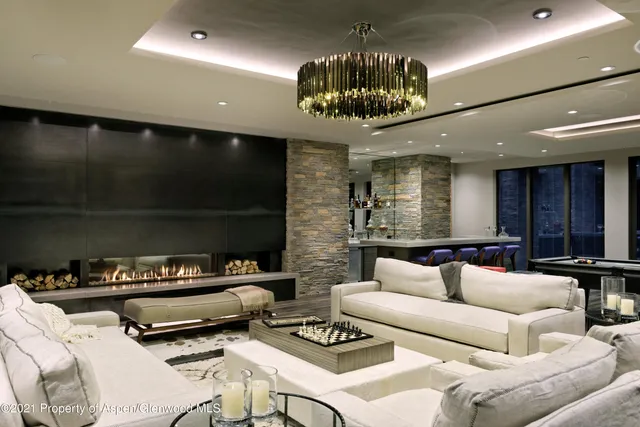 a living room with furniture a chandelier and a flat screen tv