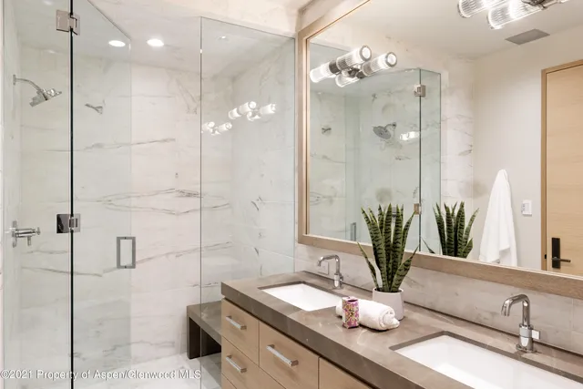 a bathroom with a double vanity sink mirror and shower