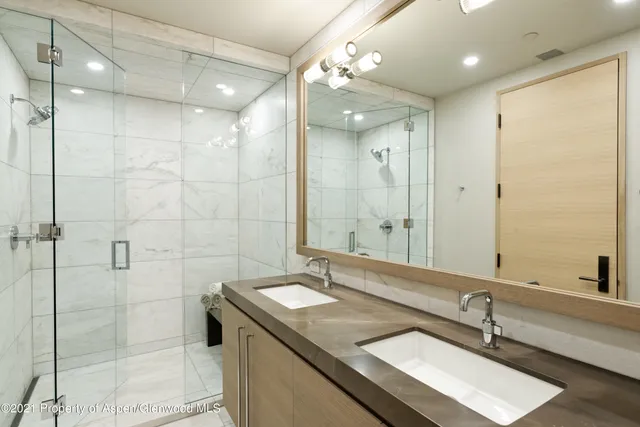 a bathroom with a sink shower and a mirror