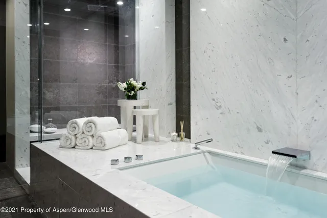 a bathroom with a tub sink and a mirror