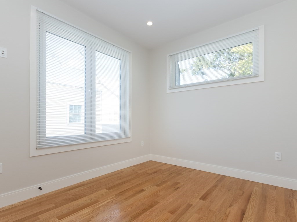 9 Tovar Street, Unit 2 Boston, MA 02122 - Photo 11 of 22 an empty room with wooden floor and windows