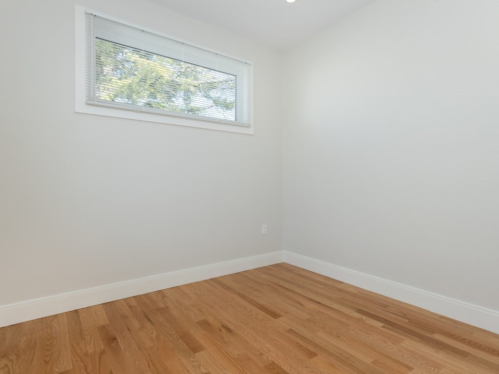 9 Tovar Street, Unit 2 Boston, MA 02122 - Photo 12 of 22 a view of an empty room with wooden floor and a window