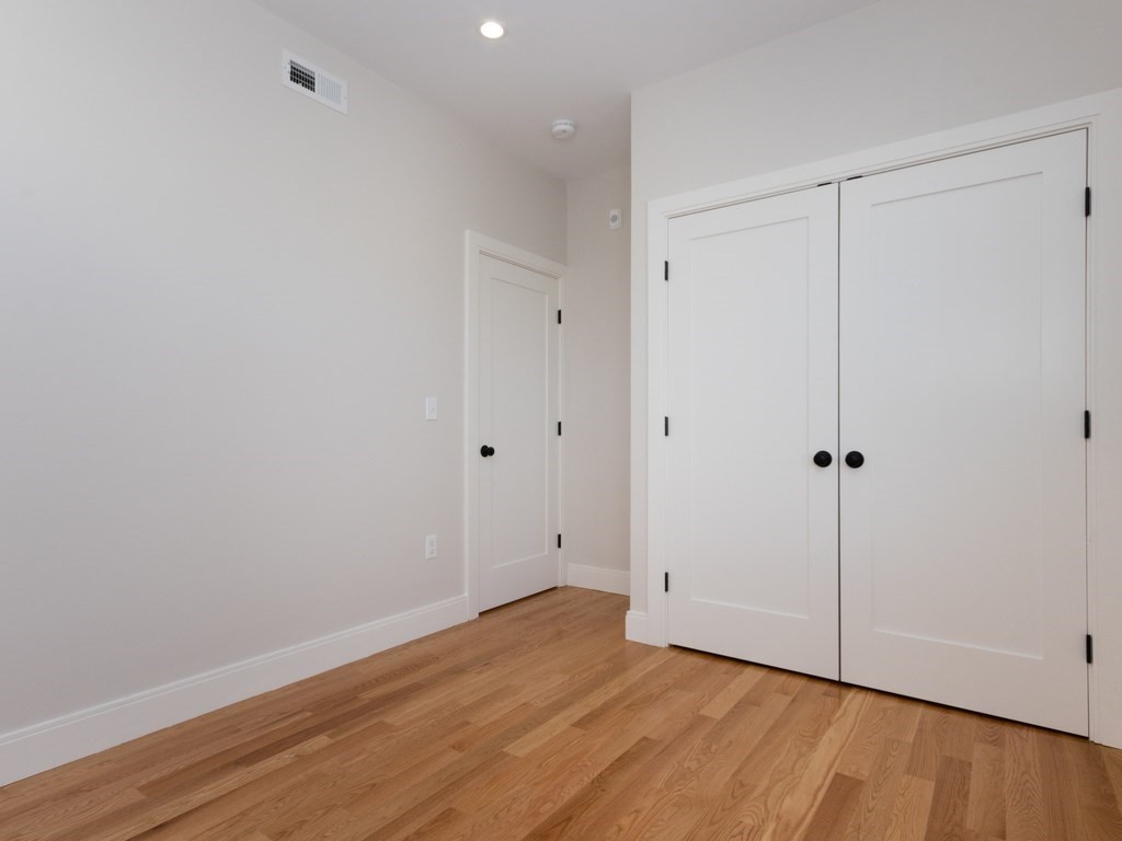 9 Tovar Street, Unit 2 Boston, MA 02122 - Photo 13 of 22 a view of an empty room with wooden floor