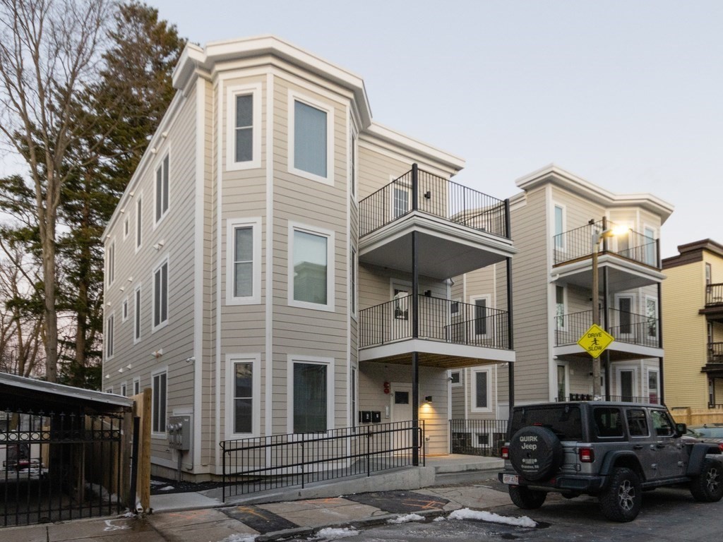 9 Tovar Street, Unit 2 Boston, MA 02122 - Photo 2 of 22 a front view of a building with lot of cars and trees