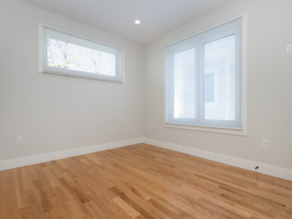 9 Tovar Street, Unit 2 Boston, MA 02122 - Photo 7 of 22 a view of an empty room with wooden floor and a window