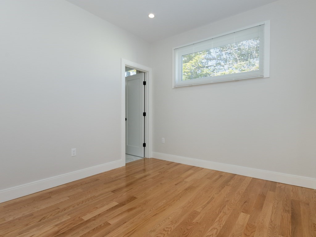 9 Tovar Street, Unit 2 Boston, MA 02122 - Photo 9 of 22 an empty room with wooden floor and windows