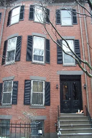 a view of a brick house with windows and entryway